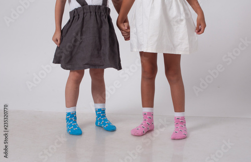 legs of two little girlfriends in knitted socks in a white studio