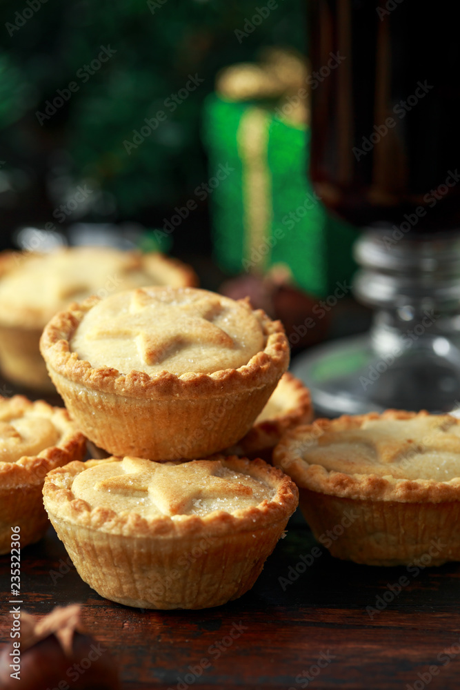 British Christmas mince pies with decoration, gifts, green tree branch on wooden rustic table British Christmas mince pies with decoration, gifts, green tree branch on wooden rustic table