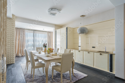 Fototapeta Naklejka Na Ścianę i Meble -  Interior of light spacious kitchen with served table in a luxury villa