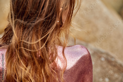 Woman's Back Covered By Golden Glitter