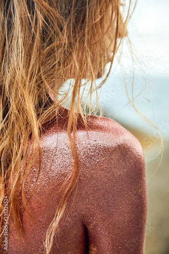 Woman's Back Covered By Golden Glitter