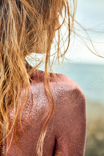 Woman's Back Covered By Golden Glitter