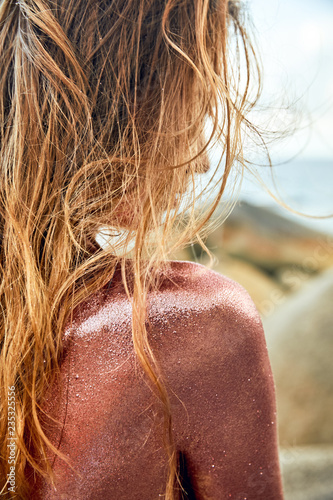 Woman's Back Covered By Golden Glitter