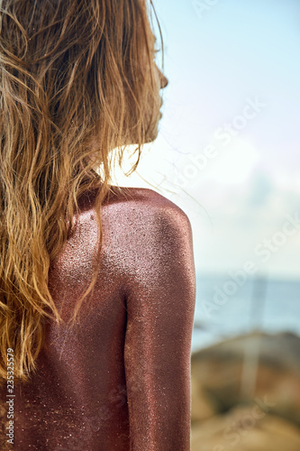 Woman's Back Covered By Golden Glitter