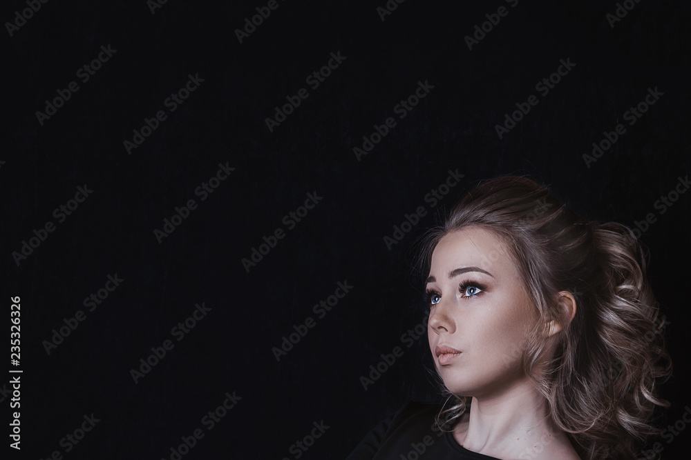 beautiful blonde girl looking sideways on black background copy space beautiful blonde girl looking sideways on black background copy space