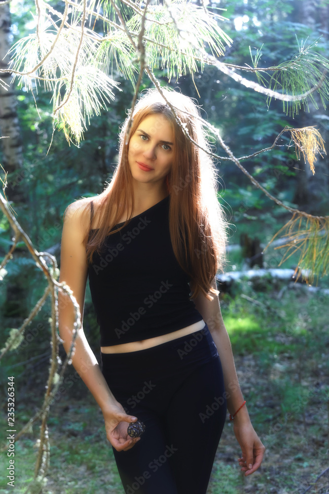 Beautiful smiling girl walking through the summer Siberian taiga
