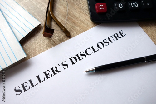 Seller`s disclosure statement with pen, calculator and   glasses in office