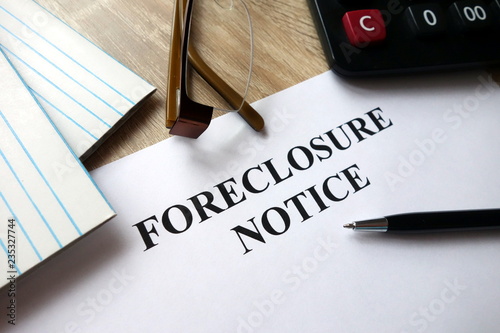 Foreclosure notice with pen, calculator and   glasses in office photo