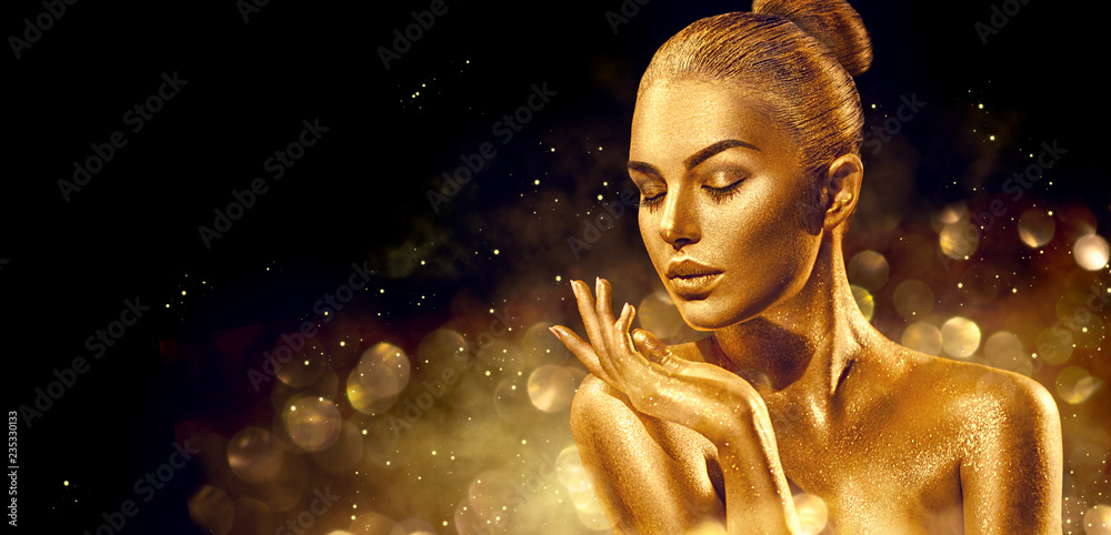 Obraz premium Christmas woman. Golden skin woman portrait closeup. Sexy model girl with holiday golden shiny professional makeup. Golden metallic body