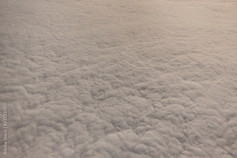 Layer of clouds taken from aircraft above scene illuminated by low evening or morning sun rays of warm golden color. Easy background photography of simple composition and empty space. Layer of clouds taken from aircraft above scene illuminated by low evening or morning sun rays of warm golden color. Easy background photography of simple composition and empty space.