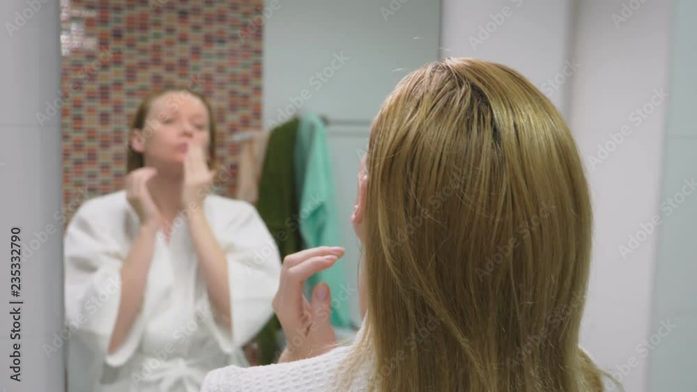 face care concept. Woman applying cosmetic lotion to take care of the skin in the bathroom. Morning hygiene face care concept. Woman applying cosmetic lotion to take care of the skin in the bathroom. Morning hygiene