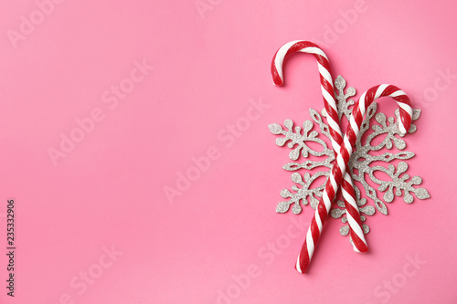 Flat lay composition with tasty candy canes and space for text on color background