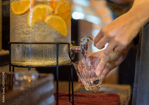 Foto Woman pouring water from dispenser