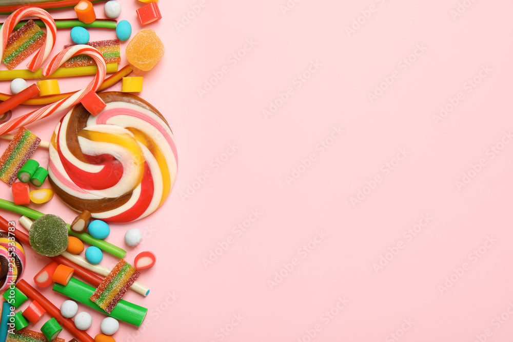 Flat lay composition with different yummy candies and space for text on color background