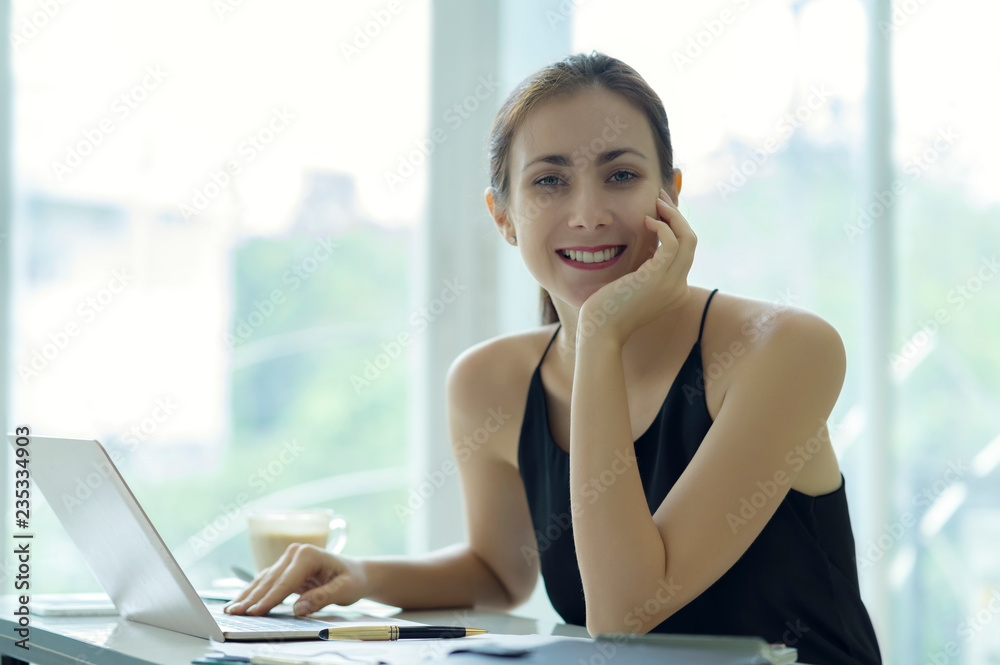 Young businesswoman working with laptop computer in office. Young businesswoman working with laptop computer in office.