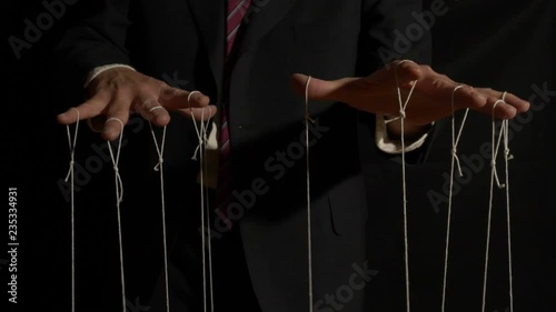 A corporate puppet master manipulating and pulling strings