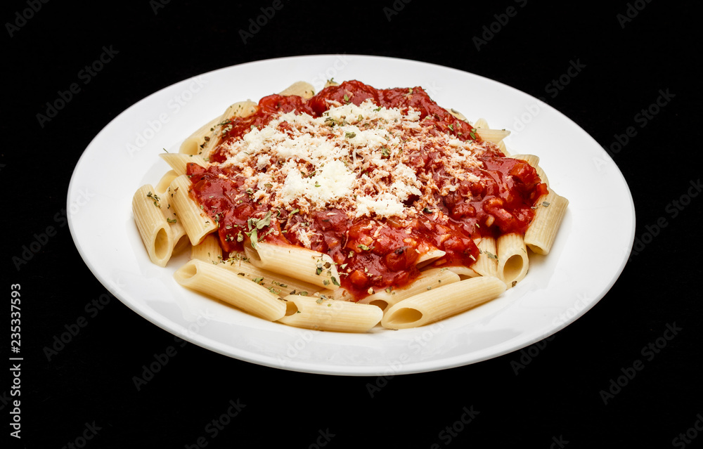 Fototapeta premium penne meal with red sauce and grated cheese, black background