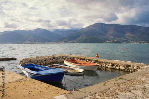 After the rain. Beautiful Mediterranean landscape with fishing boats in small harbor. Bay of Kotor, Tivat, Montenegro