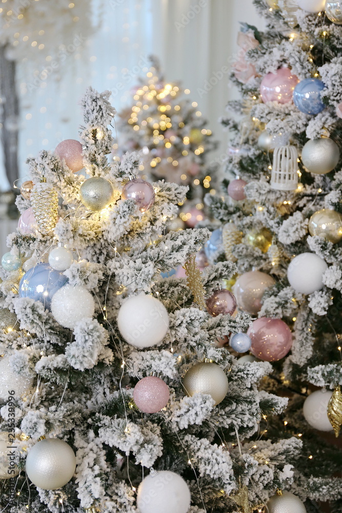elegant beautiful new year and Cristmas tree with white, pink and blue toys under the instant snow elegant beautiful new year and Cristmas tree with white, pink and blue toys under the instant snow