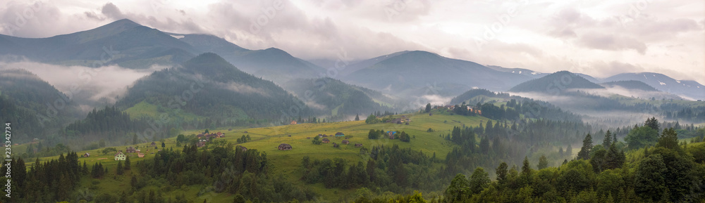 Fantastically beautiful morning in the Carpathians in the summer. amazing view of the mountain village Dzembronya foggy morning in the mountains in summer.