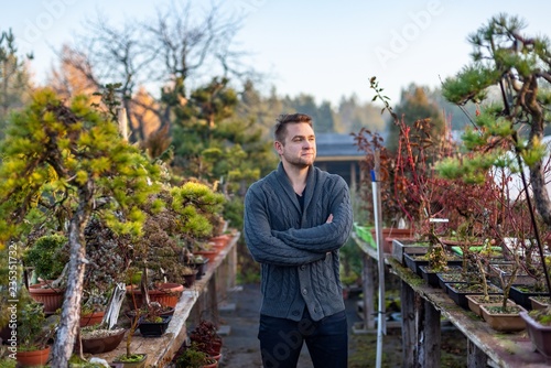 Young man bonsai artist in his bonsai farm
