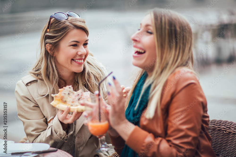 Portrait of two young women meating in cafe eating pizza outdoors,having fun together. Portrait of two young women meating in cafe eating pizza outdoors,having fun together.