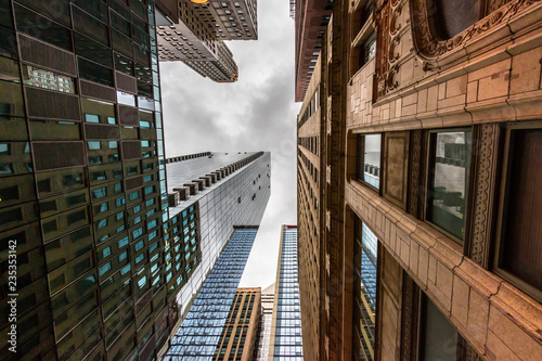 Wide-angle view looking up through tall buildings and skyscrapers in downtown Chicago Illinois