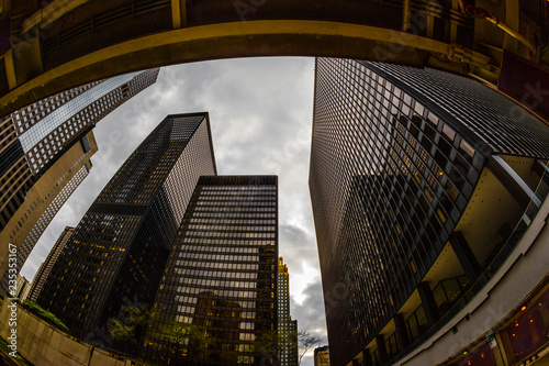 Wide-angle view looking up through tall buildings and skyscrapers in downtown Chicago Illinois