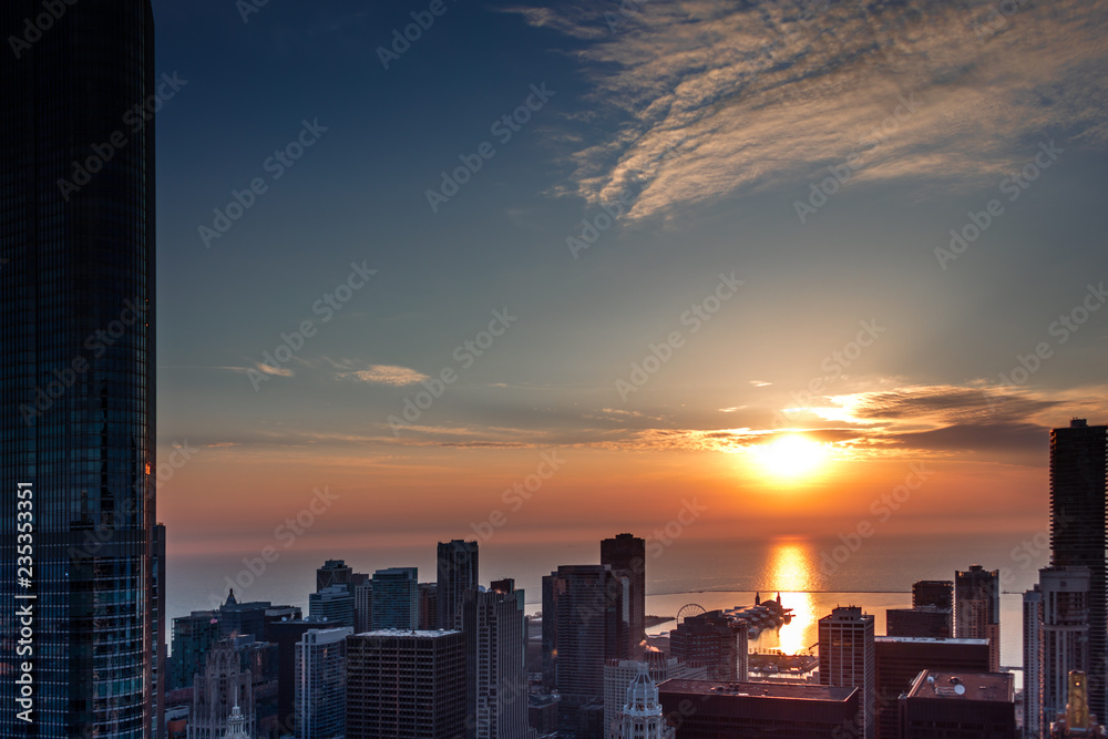 Aerial view looking out over downtown Chicago Illinois and Lake Michigan as the sun rises over the horizon