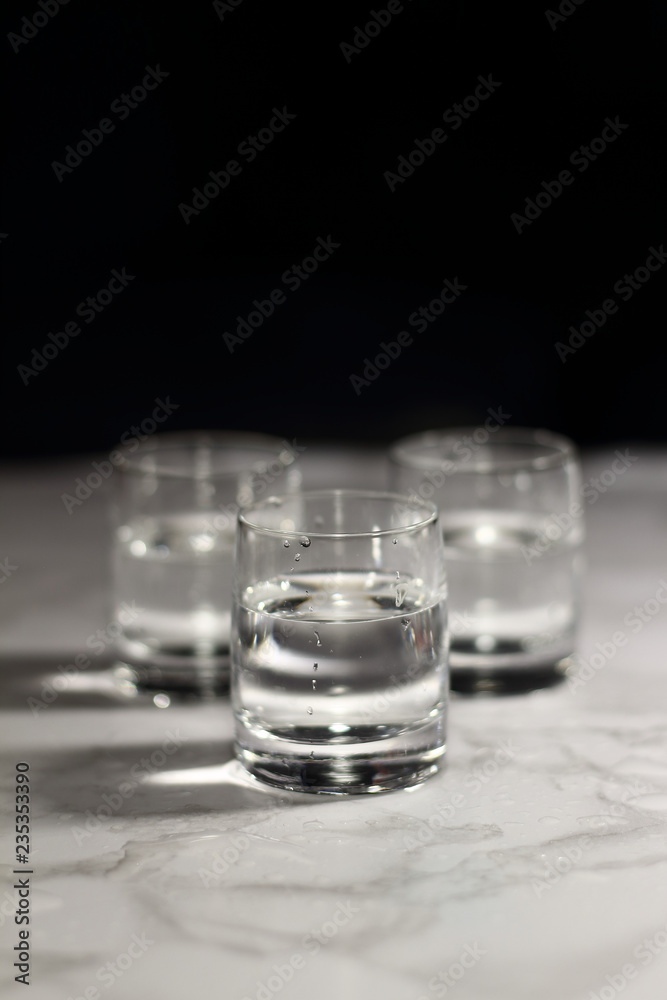 Relaxing crystal glass shot of vodka on a dark background Relaxing crystal glass shot of vodka on a dark background