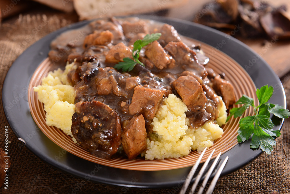 Stew with meat, mushrooms and vegetables served with groat