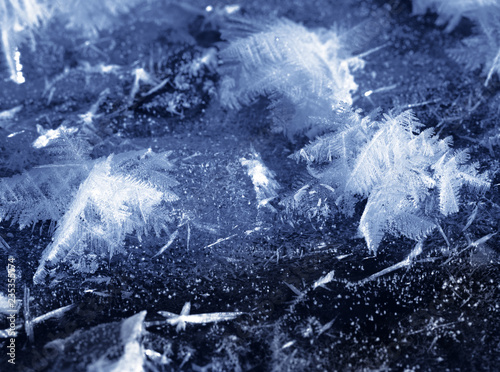 Snowflakes on ice of frozen river photo
