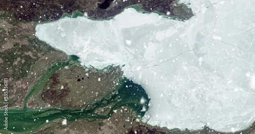 Vertical aerial ascent through heavy falling snow, over Great Slave Lake, Canada. Elements of this image furnished by NASA.  photo