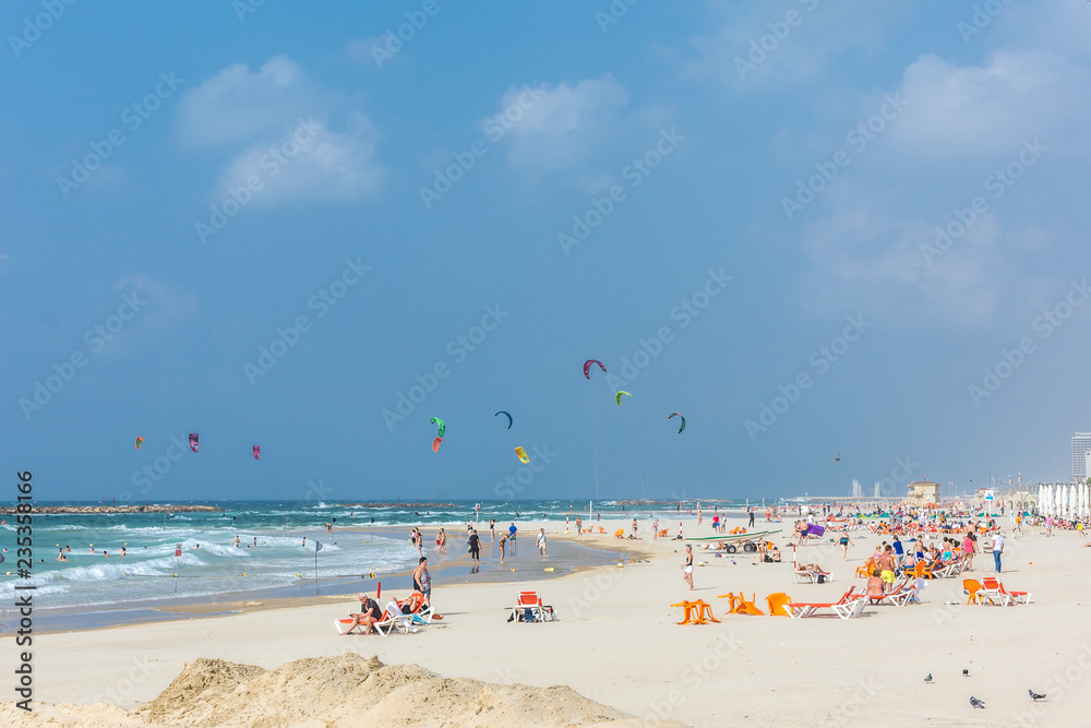 Tel Aviv, Israel - Oct 25th 2018 - Big group of people enjoying a sunny day in a beach with many kites in the air in Israel Tel Aviv, Israel - Oct 25th 2018 - Big group of people enjoying a sunny day in a beach with many kites in the air in Israel