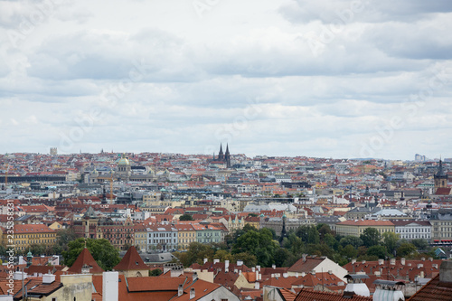 Prague panorama with colorful rooftops on a cloudy day, with The Church of St. Ludmila in the distance