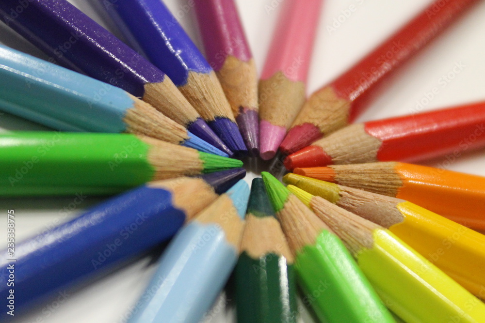 colored pencils lying around the heart on a white background colored pencils lying around the heart on a white background