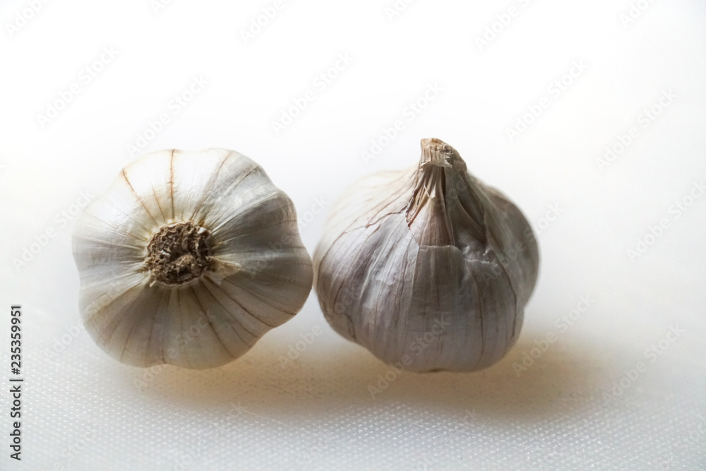 Obraz premium fresh raw garlic on white cutting board on table