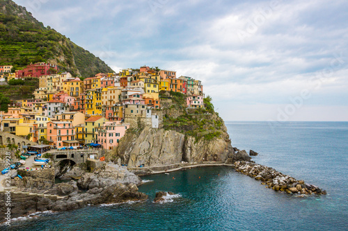 beach streets and colorful houses on the hill in Manarola in Cinque Terre in Italy 