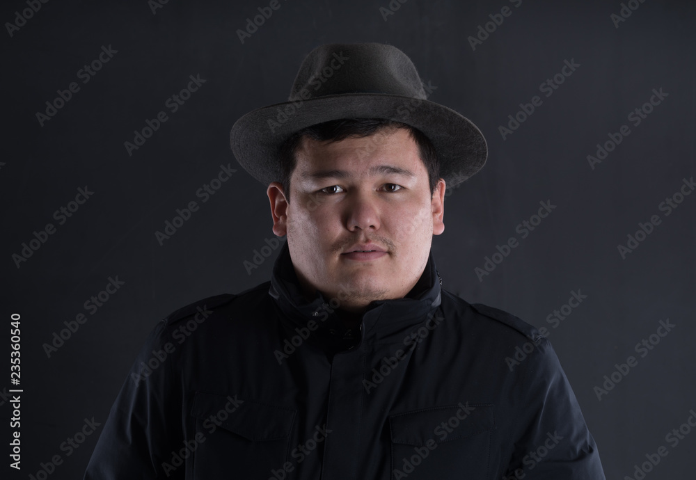 classic portrait of asian man in hat on black studio background classic portrait of asian man in hat on black studio background