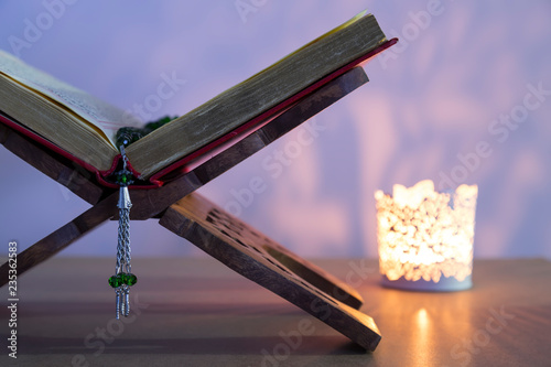Quran and rosary beads on the white background with light lantern or candle for Islamic concept. Holy book Koran for Muslims holiday, Ramadan,blessed Friday message and three months