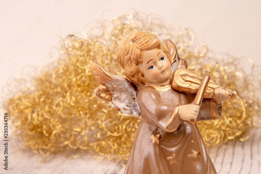 Fototapeta premium Angel with violin in front of golden hair on white wood as Christmas background