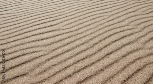 Sand on the beach as a background or texture -  Sand pattern formed by the wind