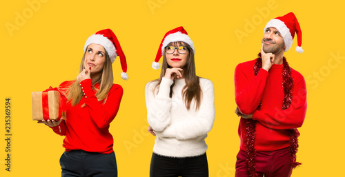 A group of people Blonde woman dressed up for christmas holidays thinking an idea on yellow background