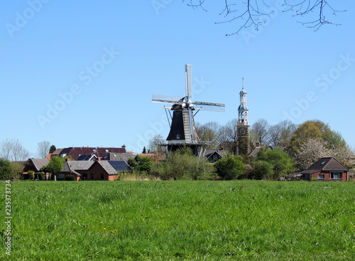Andreaskerk Reformed Church and windmill in village Spijk, Netherlands