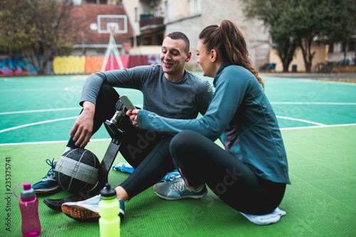 Young man with prosthetic leg enjoying with his friend at basketball court.