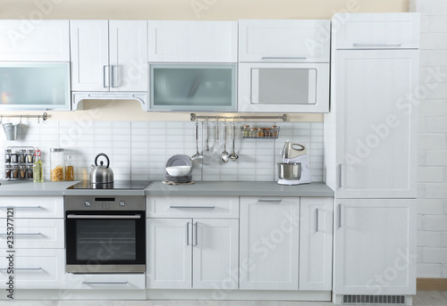 Stylish kitchen interior with modern refrigerator and furniture