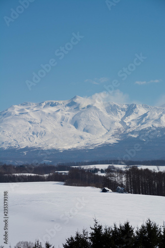 冬の火山の山頂と青空 十勝岳