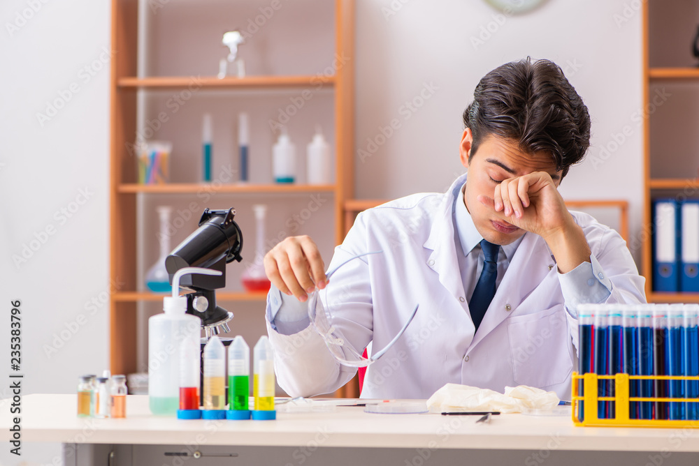 Young handsome biochemist working in the lab Young handsome biochemist working in the lab