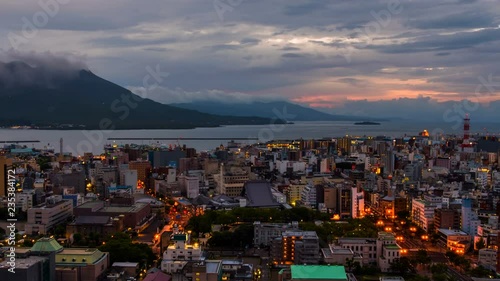 Kagoshima, Japan. View of mountain Sakurajima an active volcano. Aerial view of Kagoshima city in Japan at sunrise. Time-lapse with volcano eruption in the morning photo