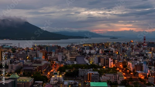 Kagoshima, Japan. View of mountain Sakurajima an active volcano. Aerial view of Kagoshima city in Japan at sunrise. Time-lapse with volcano eruption in the morning